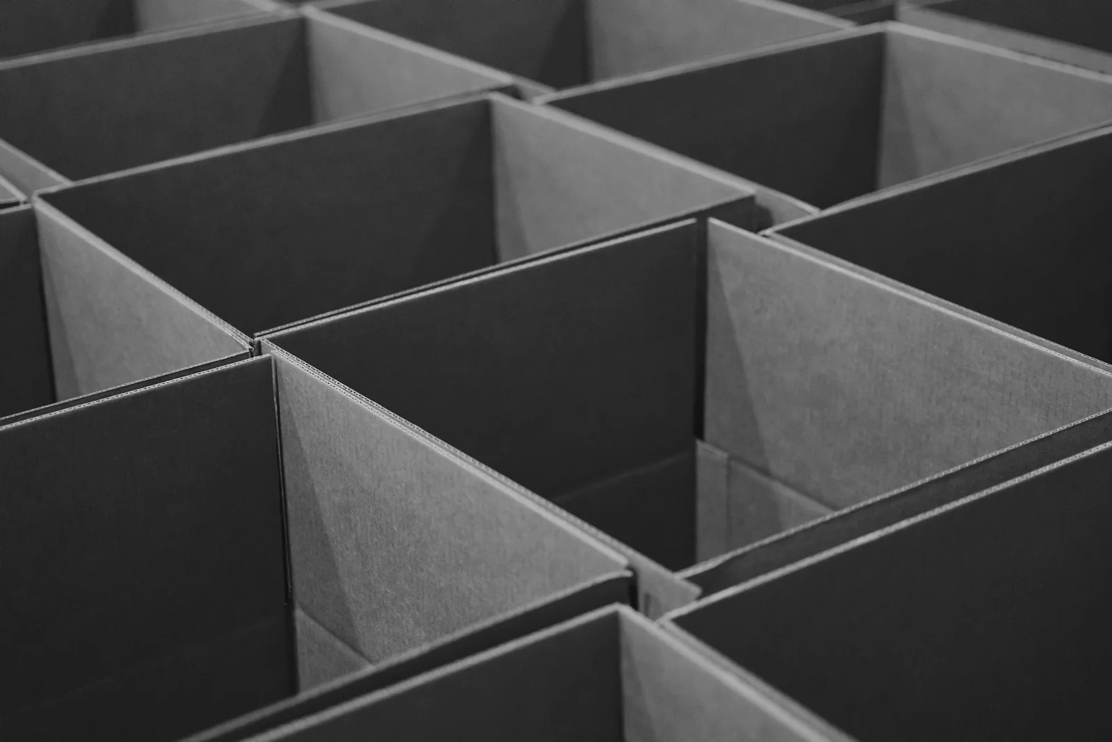 Rows of open corrugated shipping boxes lined up after assembly